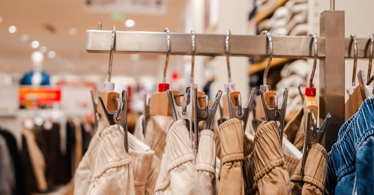 Plan détaillé de pantalons sur des cintres dans un magasin de vêtements, mettant en évidence les tendances de la mode.