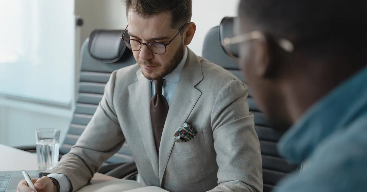 Deux professionnels ayant une discussion concentrée lors d'une réunion d'affaires dans un bureau.