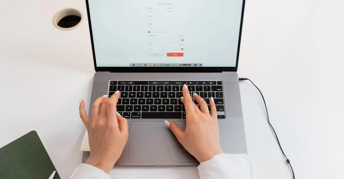 Gros plan sur des mains tapant sur un ordinateur portable dans un environnement de bureau moderne.