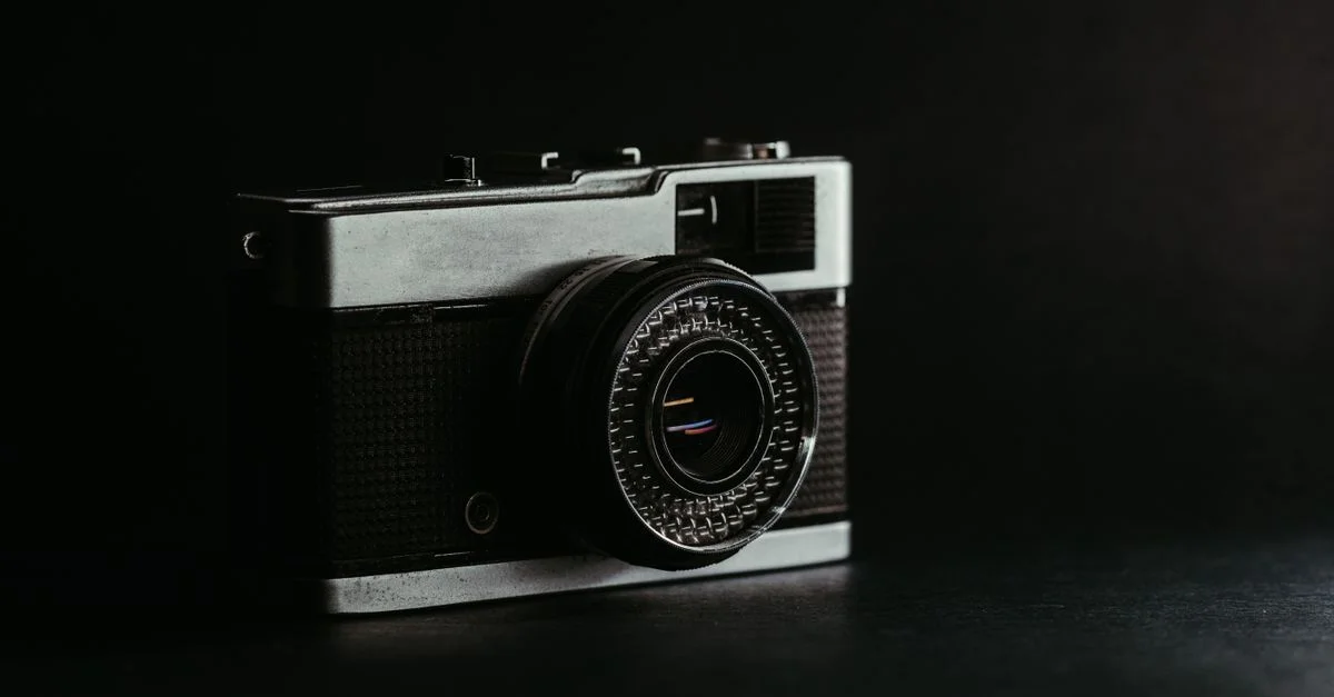 Appareil photo vintage classique avec un design élégant, présenté dans un cadre de studio sombre.