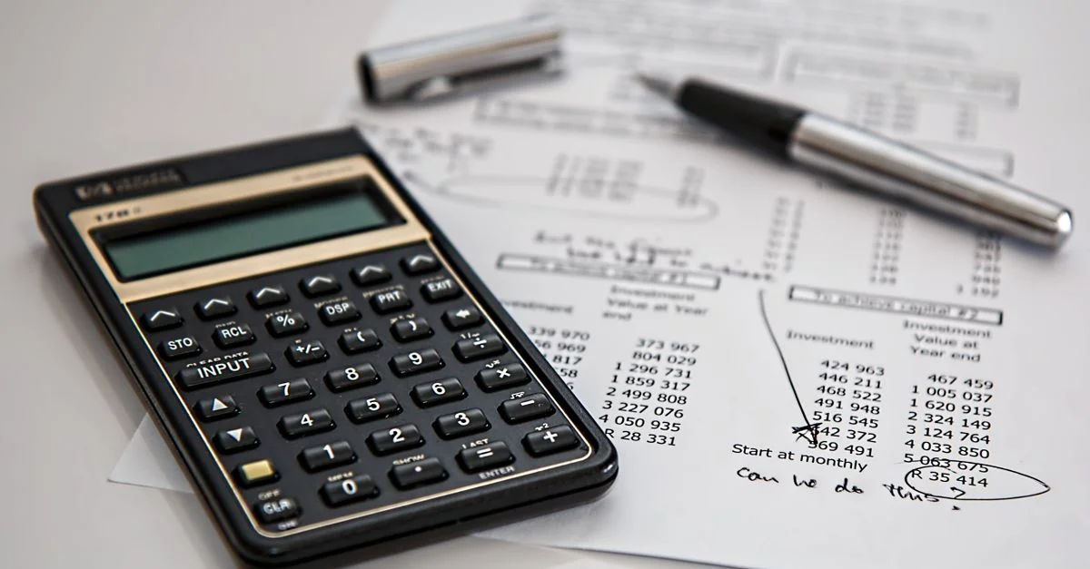 Gros plan sur des documents financiers avec calculatrice et stylo, idéal pour des thèmes de gestion d'entreprise.