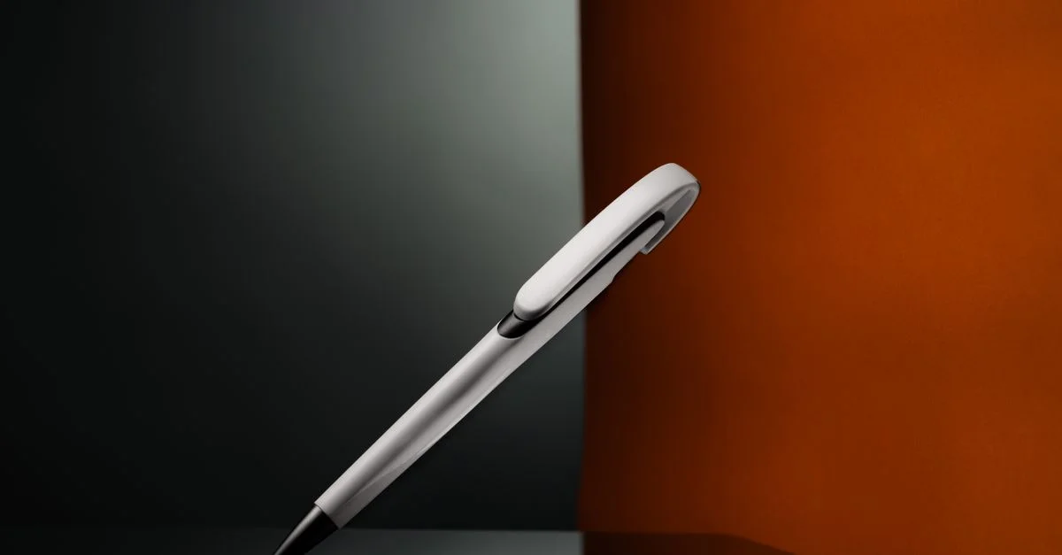 Stylo élégant sur surface réfléchissante avec éclairage artistique, mettant en avant un design minimal.