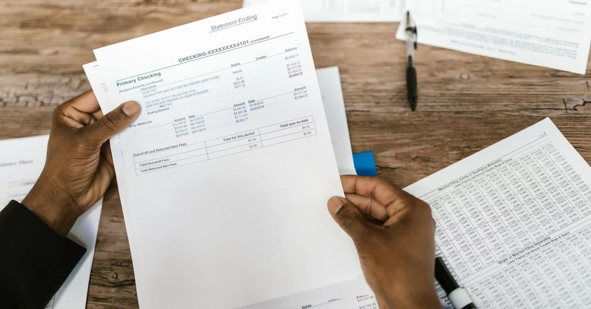 Mains tenant des documents financiers pour la préparation et l'analyse fiscale.