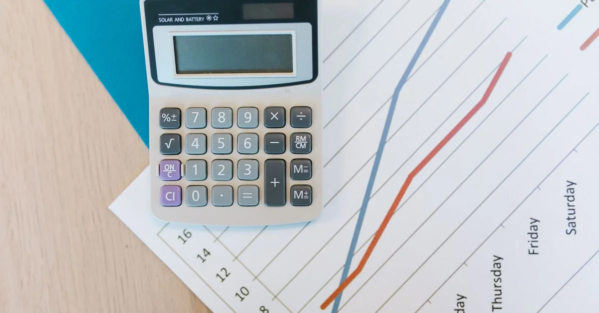 Vue de dessus d'une calculatrice et de papier à carreaux sur un bureau de bureau, parfait pour des visuels sur le thème des affaires.