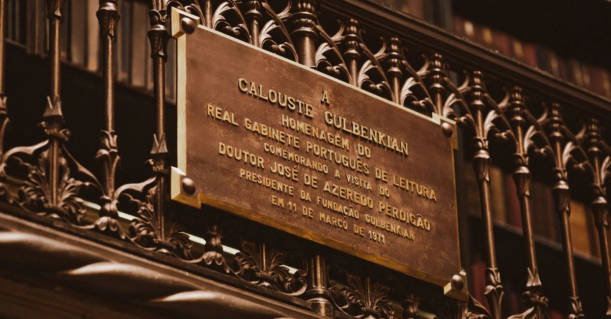 Gros plan d'une plaque historique honorant Calouste Gulbenkian dans une bibliothèque.