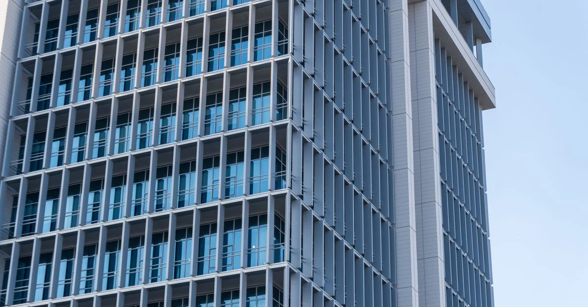 Exploration du design élégant d'un immeuble de bureaux moderne de grande hauteur doté d'une façade en verre.